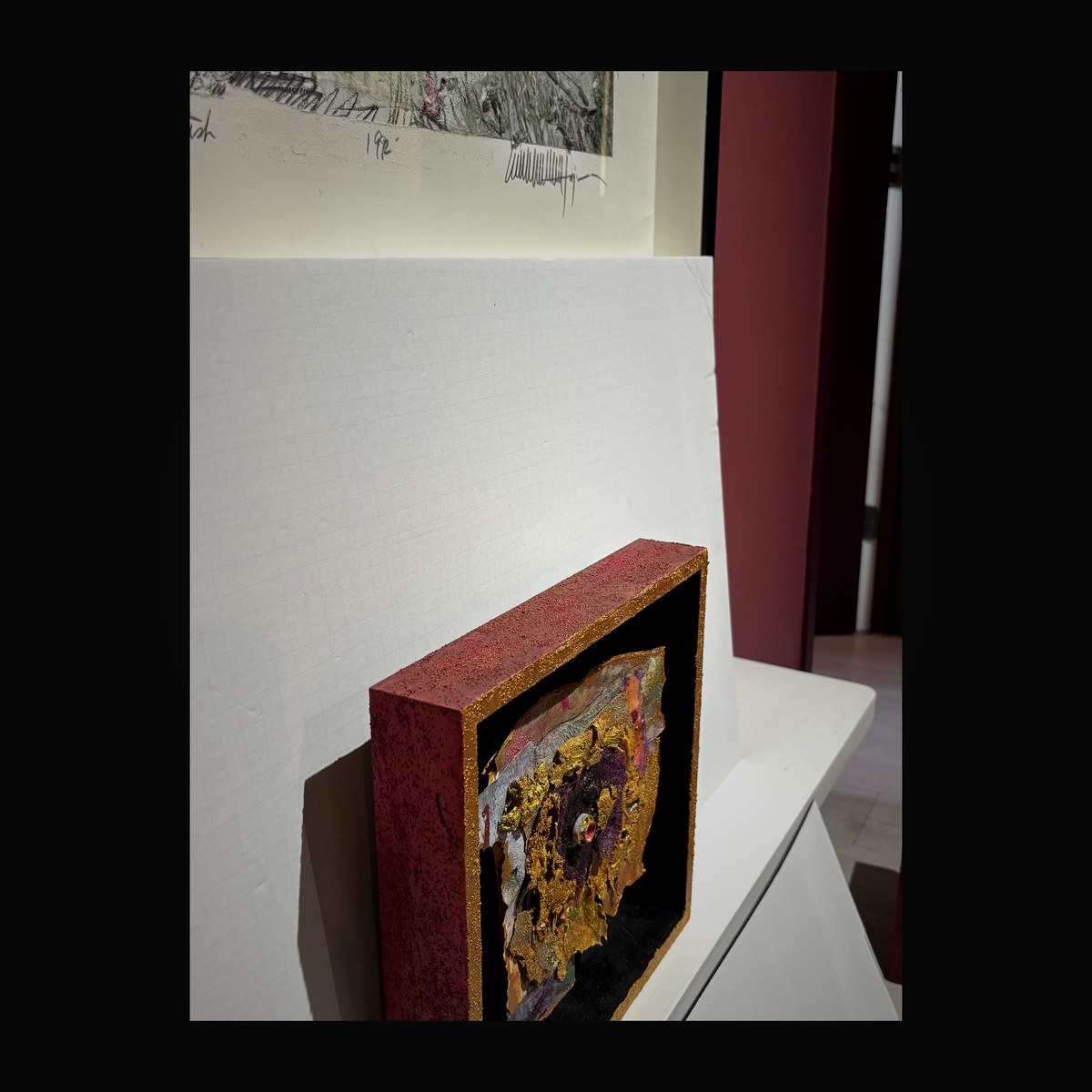 Rose-colored shadow box with gold leaf accents and gemstone