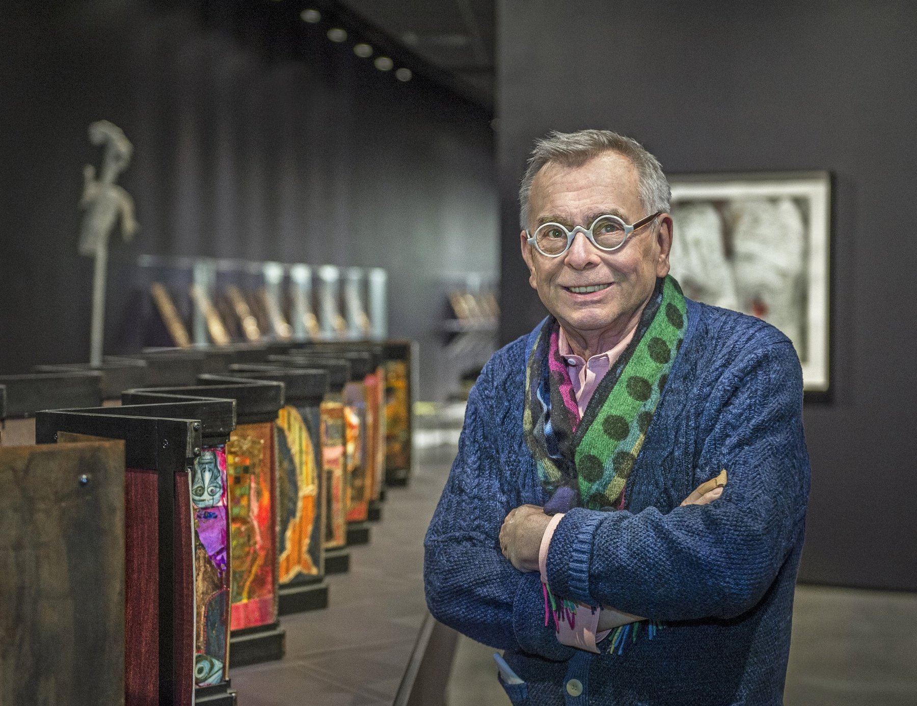 William Harper standing in his gallery exhibition surrounded by his cloisonné enamel artwork